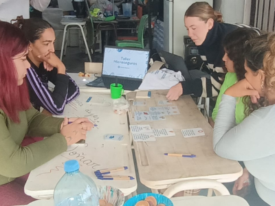 La imagen es una foto a personas que estan en una actividad grupal en la que están aprendiendo sobre microseguros.