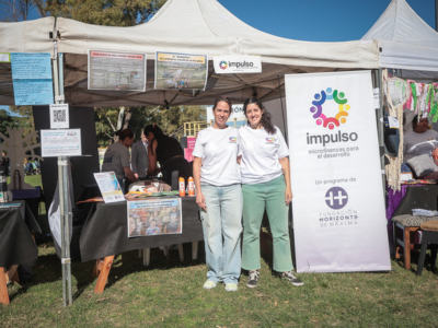 Se ven dos personas, integrantes de la ONG Impulso, en el stand de la organizacion, dentro de la Feria del Dia de las Buenas Acciones.